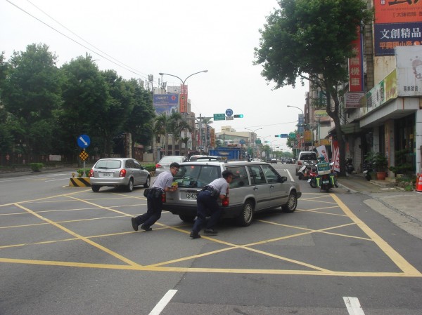 員警協助老翁將拋錨車輛推至路邊。（記者許倬勛翻攝）