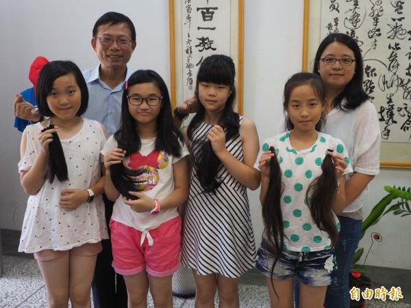 4個發起捐髮助癌友的小女生,其中魏以昕(前排右1)因媽媽林鳳茹(後排右1)曾罹癌掉髮,以昕每次都響應,並陪媽媽一起留頭髮,讓校長陳文燦(後排左1)非常感動。(記者陳鳳麗攝)