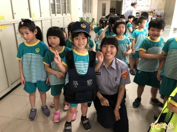 小朋友可愛模樣讓女警也笑開懷。（記者鄭名翔攝）