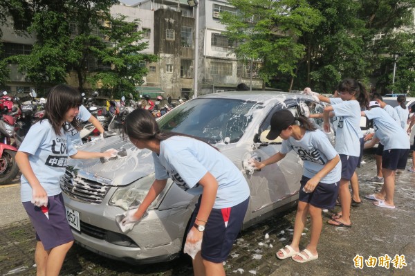 中壢高商學生頂著烈陽，當一日洗車工為老憨兒籌措經費。（記者許倬勛攝）