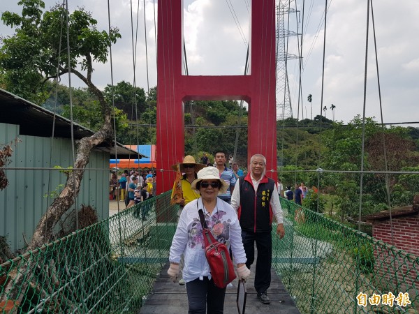 行龜橋通行儀式由行善團長陳美智（前）及蕭豐彥（左）老師偕同市議員張世賢（右）等地方各界人士敬天謝地後，與當地數百位居民一起走過吊橋。（記者王涵平攝）