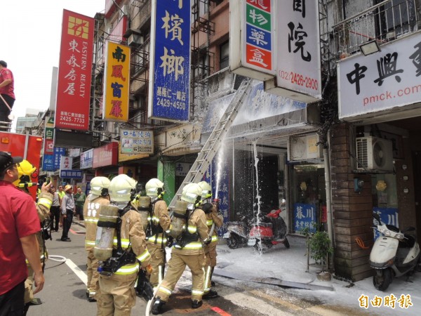 基隆市仁愛區暮川檳榔廣告看板疑似電線短路悶燒，消防隊員以化學泡沫灌救迅速撲滅火勢，幸無人傷亡。（記者林嘉東攝）