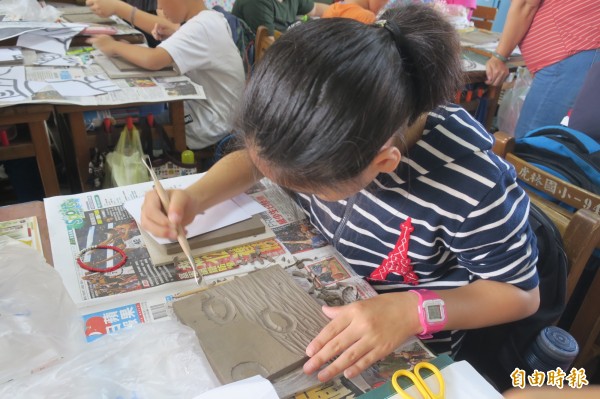 新竹市虎林社區居民和虎林國小學童一起合力改造學校通學步道一處荒廢的公佈欄,將其美化為陶板彩繪牆,成功為社區點胭脂。(記者洪美秀攝)