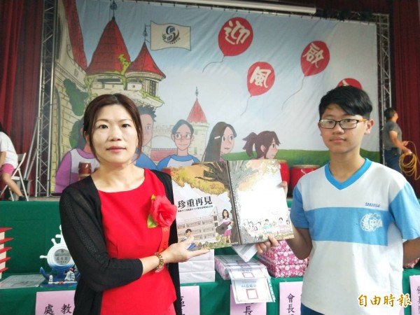 基隆市信義國中畢業典禮今天舉行,畢業生洪廷翊手繪漫畫成為畢業紀念冊封面,讓人驚艷;圖為信中校長莊焙琪(左)與洪廷翊(右)共同展示畢業紀念冊。(記者俞肇福攝)