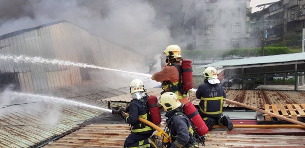 新北市板橋一間紙類裝訂工廠大火全面燃燒,消防員射水灌救。(記者吳仁捷攝)