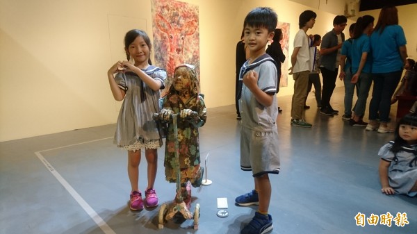 小朋友和紙製雕塑品快樂合照。(記者楊金城攝)