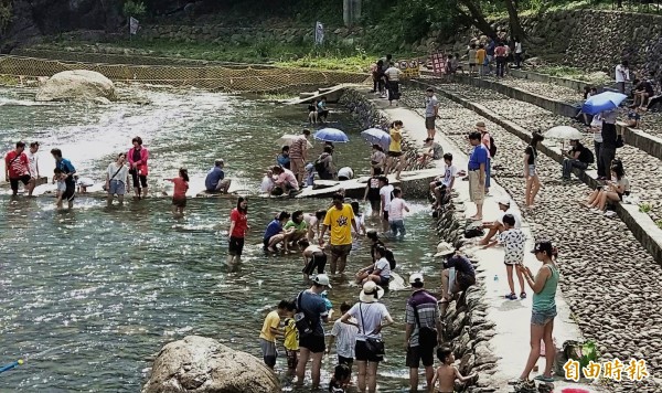 復興區小烏來風景特定區的宇內溪戲水區,7、8月期間天天開放戲水,這兩天因山區下大雨水位較高,戲水民眾擠在岸邊玩水。(記者李容萍攝)