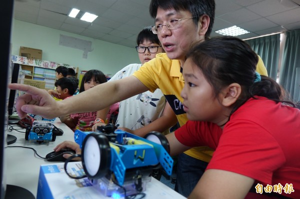 淡江大學電機系教授許駿飛,幫彰化福興大興國小學弟妹上機器人課程。(記者劉曉欣攝)