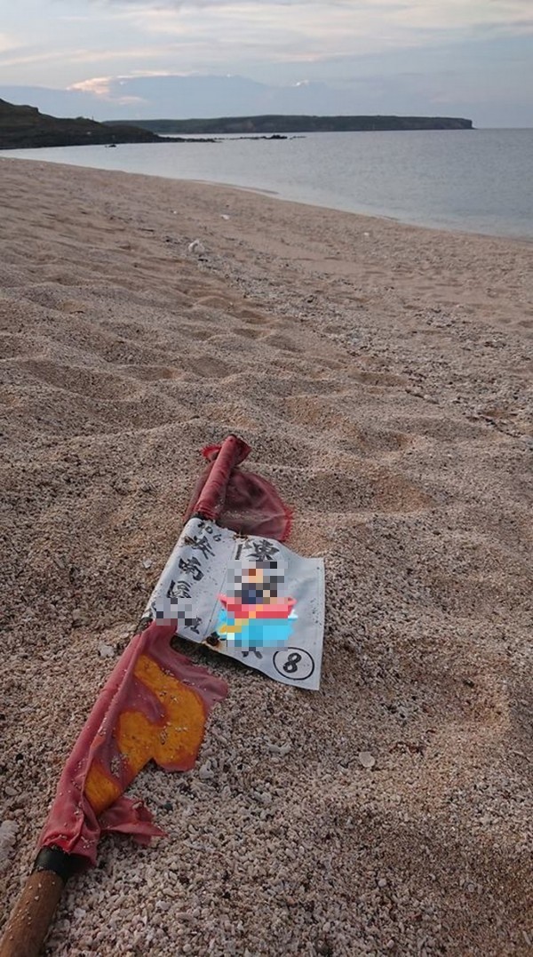 澎湖的海洋志工週六在西嶼鄉淨灘時，撿到台南漂過去的蚵棚標示旗。（海洋志工提供）