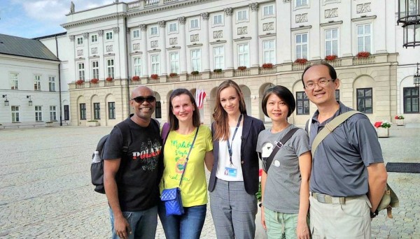 南投市平和國小英文老師李宏哲夫婦(右1、2),在波蘭旅遊時與波蘭總統府人員一起開心合照。(李宏哲提供)