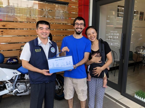移民署中區事務大隊大隊長林宏恩(左)送禮給義大利籍新住民柏丁利歐(中)。(移民署提供)
