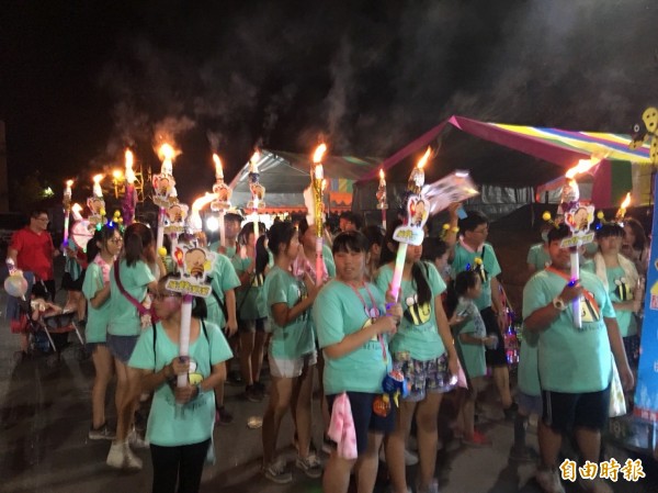 鄉親、遊客高舉火把,跟著神轎遶境、祈求平安。(記者蔡宗勳攝)