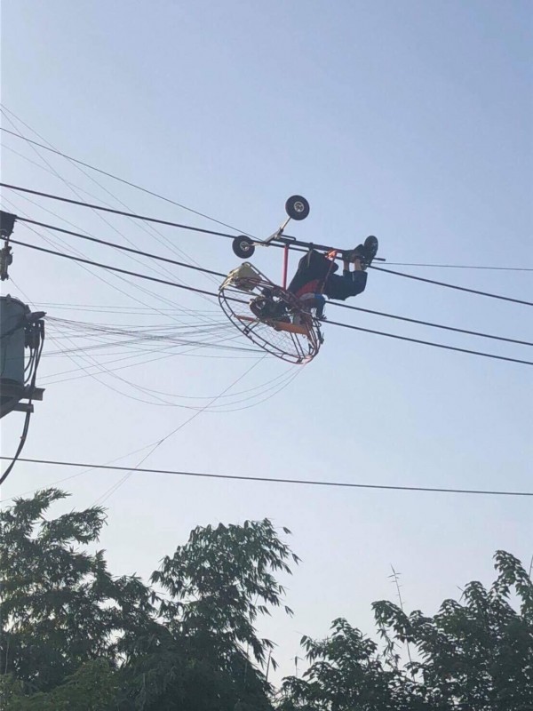 烏日發生一名玩飛行傘的男子被困在電線上,警消獲報立即救援,民眾出借吊車協助脫困,幸無大礙。(記者蘇金鳳翻攝)