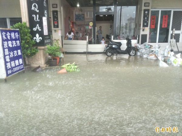 安中路的居民連忙擋水。（記者邱灝唐攝）