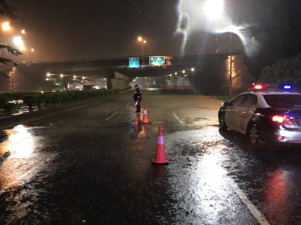 嘉義市北港路、嘉義交流道下方積淹水，警員冒雨管制。（民眾提供）