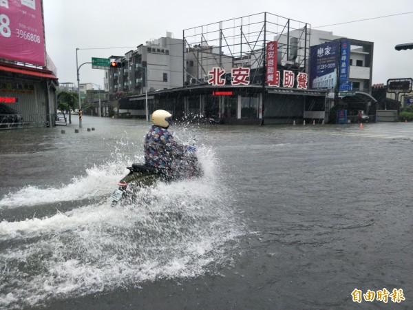 機車騎士試圖闖過積水車道。（記者邱灝唐攝）