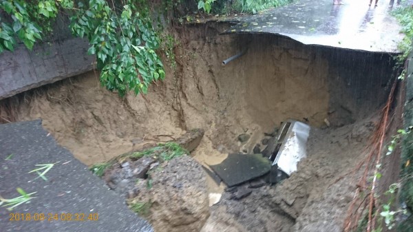 1輛廂型車摔進坑洞。（記者楊金城翻攝）