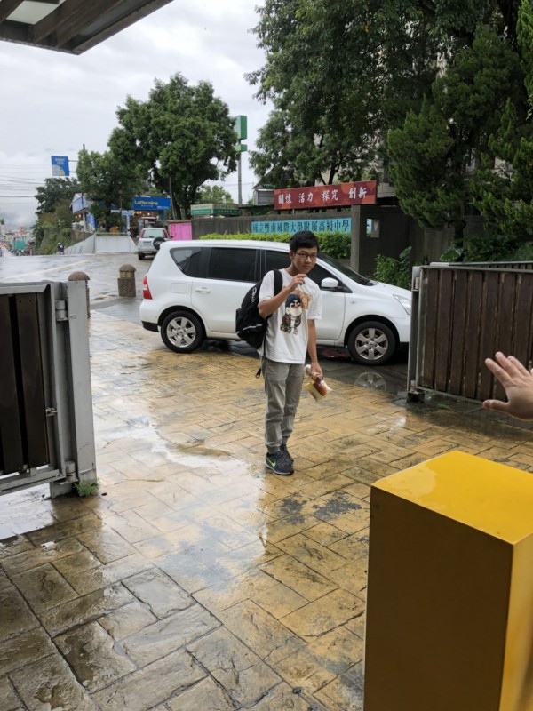 暨大附中學生到學校門口，校方人員請他趁雨小趕快回家。（暨大附中提供）