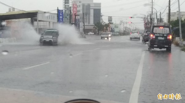 土庫建國路段積水，車輛經過濺起大量水花。（記者廖淑玲攝）