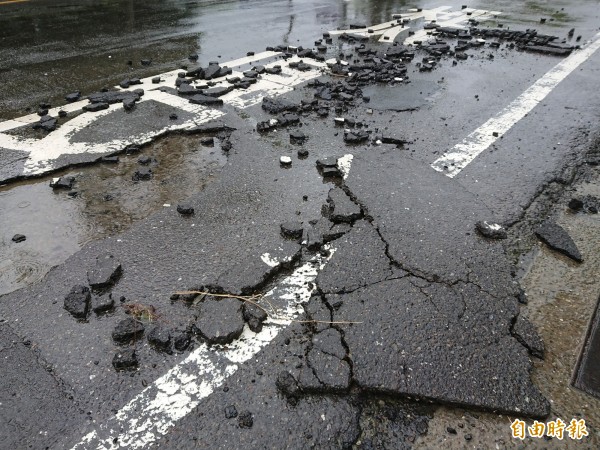 強大雨勢硬將柏油路面「剝」開來。（記者洪瑞琴攝）