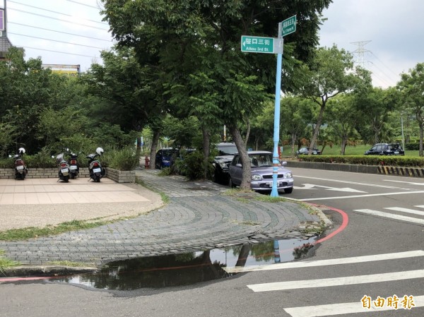 近來雨勢一波波，新竹縣竹北市民代表余政達抱怨，高鐵特定區興隆路5段與隘口三街等多處人行道無障礙斜坡轉角，疑因沒有排水孔，雨天屢見積水。（記者廖雪茹攝）