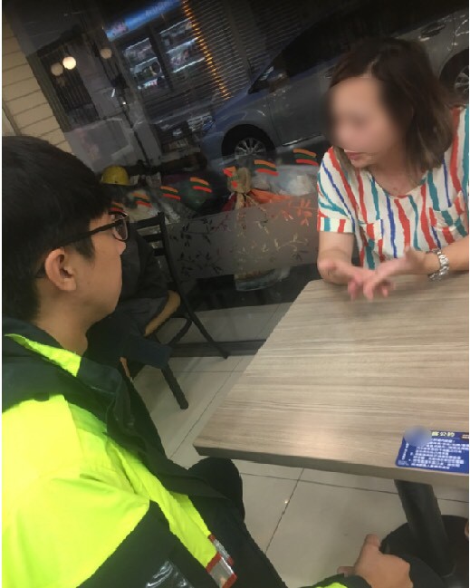 黃姓港女（右）來台尋愛，獨坐超商哭慘，巡邏員警向前關心。（記者李容萍翻攝）