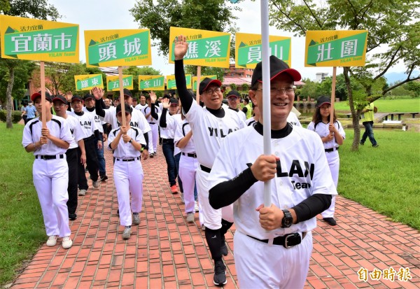 民進黨宜蘭縣長參選人陳歐珀，今率黨內十二鄉鎮市長、縣議員參選人著棒球裝，從縣議會走到縣府登記。（記者張議晨攝）