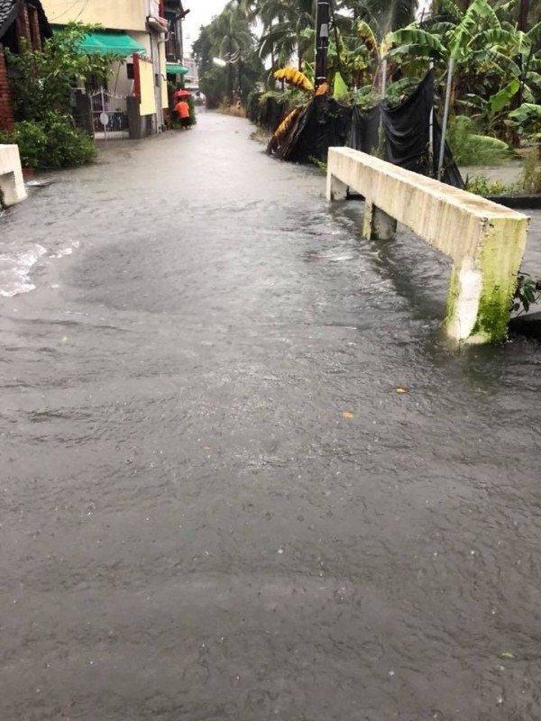 長治鄉隘寮溪相闗排水滿溢，溪水都滿到路面上了。（圖由古佳川提供）