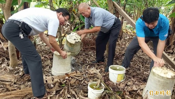 南投縣衛生局長黃昭郎（左）指導民眾將戶外容器倒置，避免積水造成病媒蚊孳生。（記者謝介裕攝）