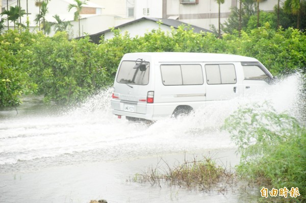 南州萬華村仍舊泡在水裡，車輛經過激起大片水花。（記者陳彥廷攝）