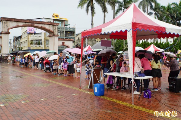 文昌國小闖關迎新，親子雨中排隊闖關。（記者詹士弘攝）