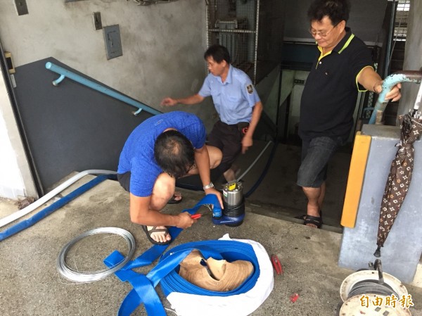 瑞豐國小淹水，家長協助抽水。（記者黃旭磊攝）