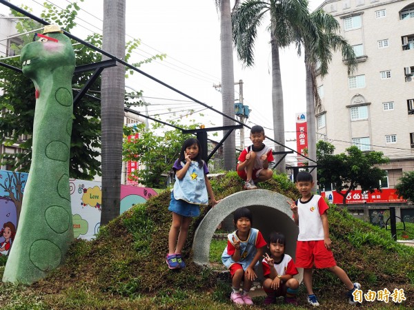 建國國小幼兒園新建一座遊戲區，結合該校「DINOS恐龍」特色主題，打造「QQ龍涵洞」，讓小朋友親土、攀爬。（記者陳昀攝）