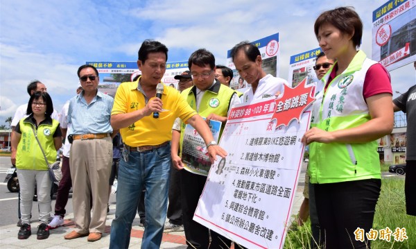 民進黨宜蘭縣黨部今赴羅東鎮踢館，質疑林姿妙9年鎮長任期多項政見「跳票」，縣議員劉添梧（穿黃衣者）還酸林姿妙，「趕快回來把工作做好再說！」（記者張議晨攝）