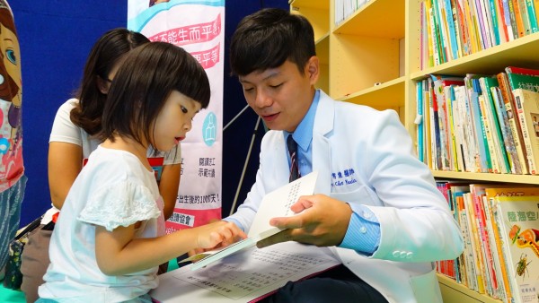 新北市立圖書館汐止分館舉辦「從0種下閱讀種籽，發芽書香的芬芳」活動，邀台北醫學大學附設醫院家醫科醫師陳宥達（右）開立「閱讀處方」。（新北市立圖書館汐止分館提供）