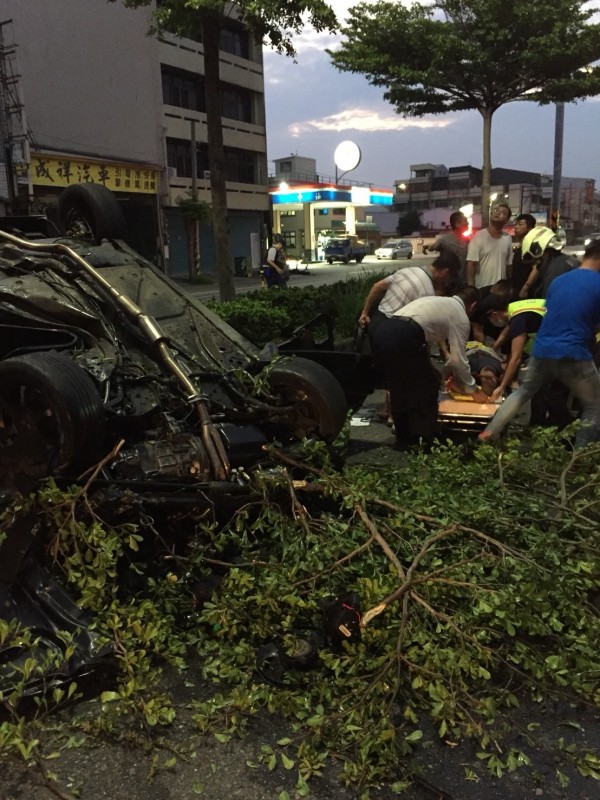 轎車撞斷路樹後翻覆，消防員將陳姓駕駛救出送醫急救。（記者湯世名翻攝）