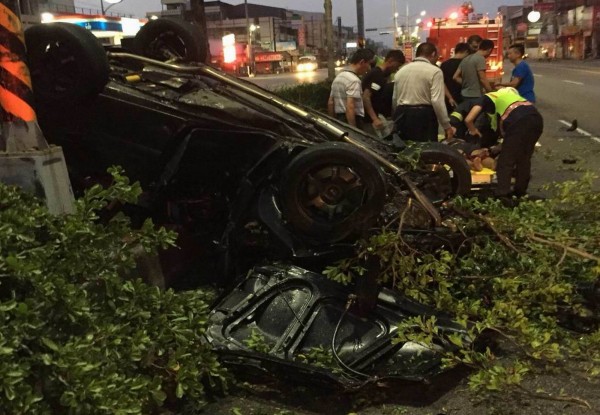 轎車撞斷路樹後翻覆，撞成廢鐵，消防員將陳姓駕駛救出送醫急救。（記者湯世名翻攝）