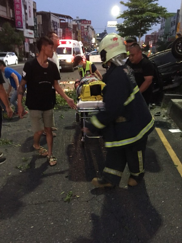 轎車撞斷路樹後翻覆，撞成廢鐵，消防員將陳姓駕駛救出送醫急救。（記者湯世名翻攝）