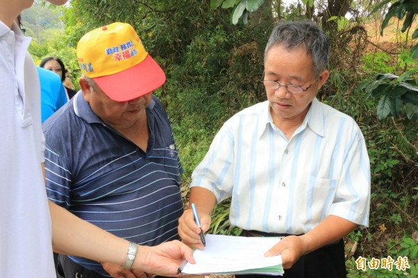 地主在代表會主席見證下，簽下同意書，將土地提供給公所闢路。（記者鄭名翔攝）