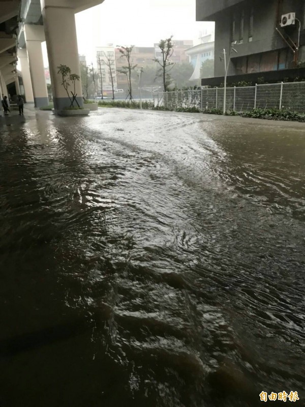 基隆市上午大雨再下，成功國小側門旁積水，人車通行不便。（記者俞肇福攝）