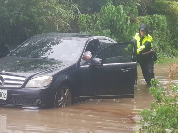 警方與駕駛幫忙讓車子脫困。（記者吳昇儒翻攝）