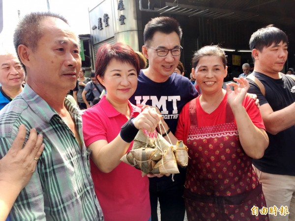 國民黨台中市長參選人盧秀燕（左二）在東興市場拜票時，攤商送上一串粽子。（記者張菁雅攝）