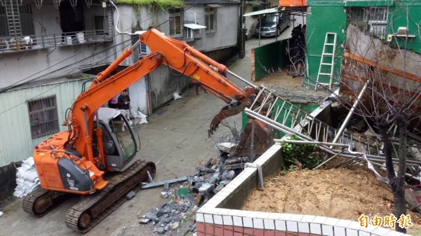 基隆市新西街民宅違建外擴部分,基隆市府今天繼續拆除工作。(記者俞肇福攝)