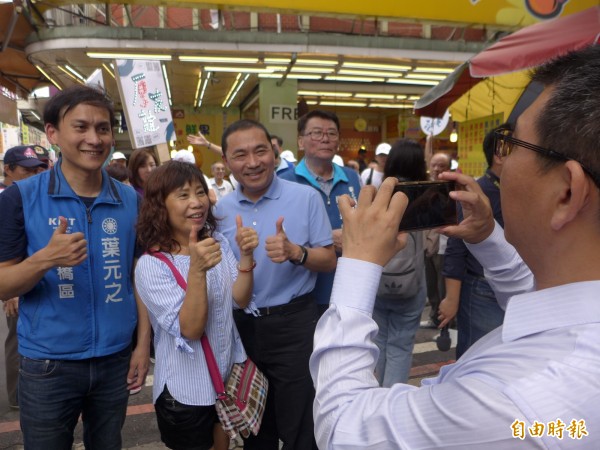 國民黨新北市長參選人侯友宜到板橋區幸德市場拜票，和熱情民眾合影。（記者李雅雯攝）