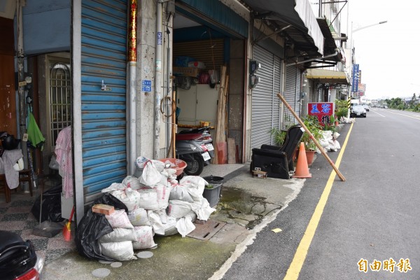 屏東市光復路局民家家戶戶準備沙石對抗淹水。（記者葉永騫攝）