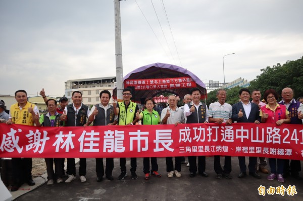 神岡區國道1號北上邊坡旁的聯外道路通車祈福，多位神岡區里長拉紅布條感謝市長林佳龍。（記者歐素美攝）