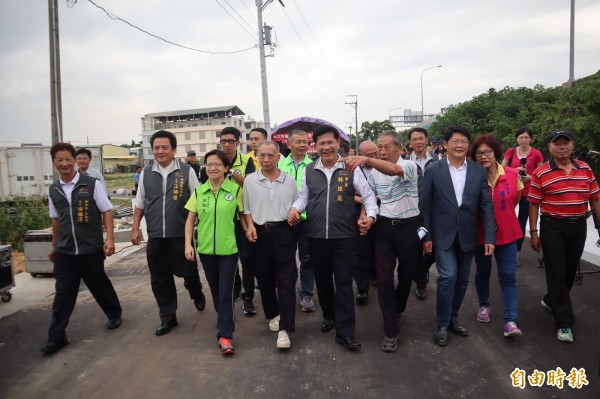 神岡區國道1號北上邊坡旁的聯外道路通車，市長林佳龍拉著獻地的農友江朝宗（右四）及魏金波（右六）一起試走寬敞的馬路。（記者歐素美攝）