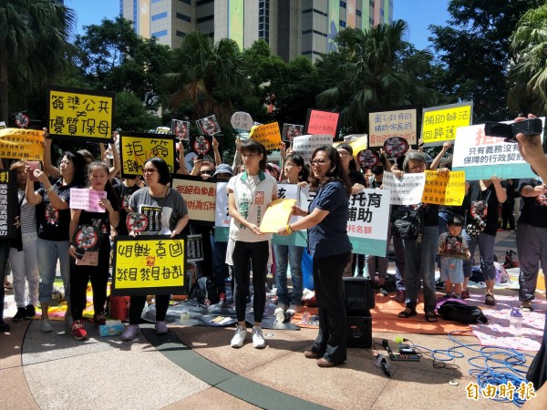 反對準公共化要求簽約的保母,今天齊聚到新北市府前陳情;社會局科長林秀穗出面接受陳情信,表示會將意見轉達到中央。(記者何玉華攝)