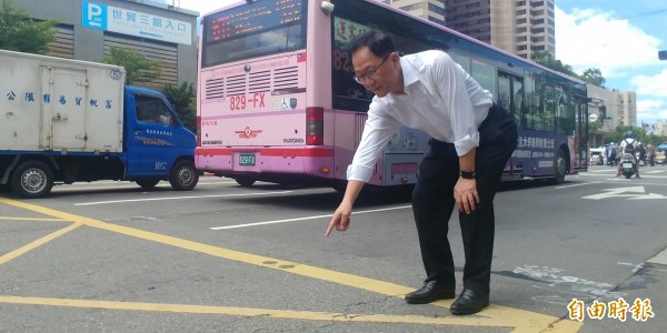 國民黨台北市長參選人丁守中今天把記者會拉到馬路上開,指著坑坑疤疤的路面,批評台北市長柯文哲不把路平當回事。(記者簡惠茹攝)