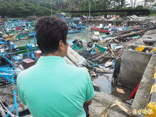 尚武漁民望著被龍捲風掃過的殘破景況，憂心未來沒膠筏出港捕魚了。（記者王秀亭攝）